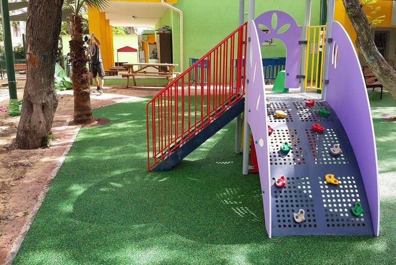 משטח גומי ירוק סביב מתקני משחק